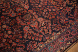 Intricate floral sprays on the navy field and palmette border of an antique Persian Mohajeran Sarouk rug.