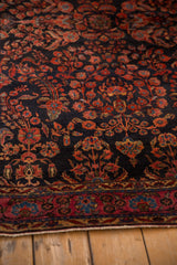 Detailed view of the short, even pile and intricate floral sprays on this antique Sarouk rug.