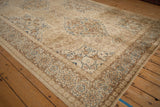 Corner view of a vintage Tabriz rug, highlighting its floral border and distressed, even-worn pile.
