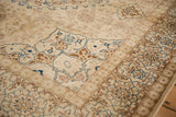Partial starburst medallion corner and floral border on a distressed Persian Tabriz carpet.