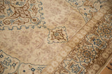 Floral cartouche border in blue and brown on a distressed vintage Tabriz carpet with a short, even pile.