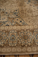 Detailed view of the floral cartouche border and corner spandrel on the distressed Tabriz carpet.
