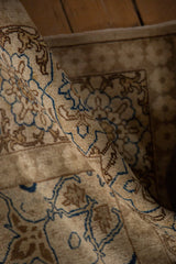 Folded view of a vintage Tabriz carpet highlighting its dense, short pile and arabesque design.