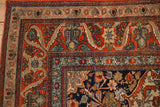 Antique Kashan rug corner, showing cherry red field with floral arabesques and patterned borders.