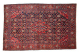 Antique Persian Sarouk rug with a red concentric medallion and corner spandrels over a navy blue field.