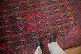 A perspective of the antique Sarouk's rich navy field with dense henna plant design motifs.