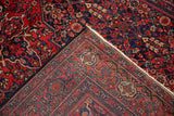 Folded corner of an antique Sarouk rug showing the detailed weave and hand-knotted pile.