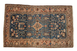 Vintage Arak rug with a floral medallion on a sapphire blue field and a complex dusty rose border.