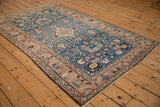Angled perspective of a vintage Arak rug, displaying its floral patterns and sapphire blue field.