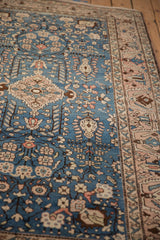 Angled view of a vintage Arak rug, showing the low-pile texture and intricate floral pattern.