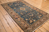 Vintage Persian Arak rug from an angle, showcasing the full medallion and floral field.