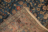 Folded corner of a vintage Persian rug showing its sapphire blue pile and detailed woven back.
