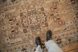 Distressed vintage Hamadan rug with even wear, showcasing geometric motifs and muted beige tones.