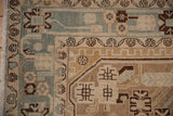 Distressed Hamadan rug corner, with fringe and geometric-floral border in sand and slate blue.