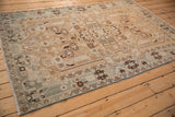 Distressed vintage Hamadan rug with geometric dark brown and slate blue vine motifs.