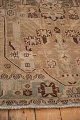 Distressed vintage Hamadan rug corner, geometric pattern in sand, slate blue, and coffee brown.