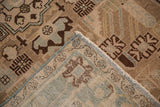 Distressed Hamadan rug close-up: geometric sand, beige, blue patterns, worn pile, woven back, fringe.