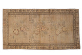 Antique distressed Karabagh rug with pictorial lions and rose bouquets on a worn sand field.