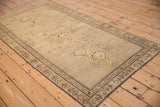 Side view of an antique Armenian Karabagh rug detailing its stylized border and pictorial field.