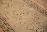 Charcoal lion motifs and rose bouquets on the distressed low-pile field of an antique Karabagh rug.