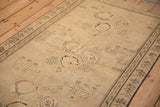 Angled view of a distressed Karabagh rug showing its low pile and mostly even wear to the knot heads.