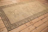 Angled view of an antique Armenian Karabagh rug showing its even, low pile and scattered pictorial motifs.