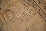 Sword-bearing lion-like animal motif woven in charcoal on a sandy-beige antique Karabagh rug.
