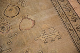 Detail of a stylized lion-like animal on the worn, sandy field of an antique Karabagh.