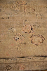 Close view of the hand-knotted texture and charcoal-outlined rose bouquets on a distressed rug.