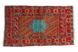 Antique Anatolian rug with a stepped, abrashed aquatic blue medallion on a cherry red field of botehs.