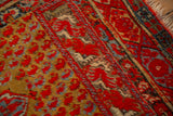 Antique Anatolian rug corner showing low pile, red floral cartouche border, and saffron botehs.