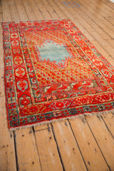 Full perspective view of an antique Anatolian rug's abrashed blue medallion and cherry red boteh field.