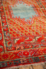 Time-softened texture of an antique Anatolian rug's stepped blue medallion and red boteh field.