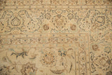 Corner view of a distressed Kashan carpet's floral border with evenly worn, low-pile texture.