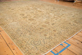 Angled perspective across the distressed floral field of a vintage Kashan carpet.