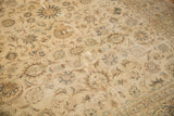 Textured low pile of a distressed Kashan rug, showing even wear across its faded floral vines.