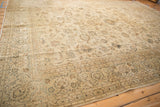 Angled perspective showing the even wear and soft texture of a vintage Kashan floral rug.