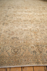 A perspective view across the distressed floral field of a vintage Persian Kashan carpet.