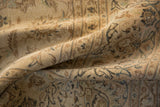 Textured low pile of a distressed Persian Kashan showing even wear to the sandy-toned knot heads.