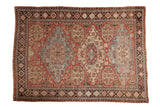 Antique Caucasian Soumac carpet with three oversized geometric medallions in brick red, dusty blue, and charcoal.
