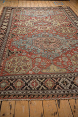 Perspective view of a Caucasian Soumac carpet's intricate geometric guls and wave-motif border.