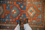 Antique Kazak rug detail with geometric hook and latch motifs in madder root red, sapphire blue, and mallard green.
