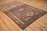 Antique Kazak rug's triple geometric borders with floral and plant motifs, madder red, blue.