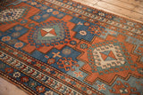 Antique Kazak rug's geometric borders and hook and latch motifs in madder red, sapphire blue.