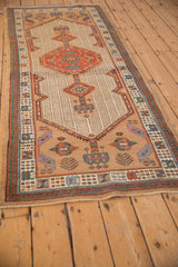 Vintage Serab runner shown at an angle, displaying its central red medallion and geometric border design.