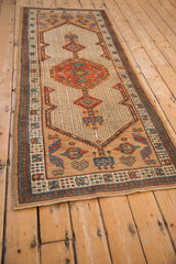 Angled view of a vintage Serab rug runner, showing its geometric design and camel-colored field.