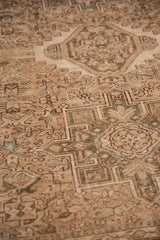 Low, even pile of a vintage Karaja rug with geometric motifs in sand and dusty green.