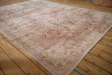 Faded fuchsia and terra cotta floral pattern with distressed texture on a vintage Kaisary rug.