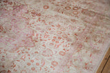 Distressed vintage Kaisary carpet border with floral motifs in soft fuchsia and terra cotta.