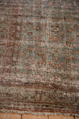 Distressed Hamadan rug texture showing dusty blue, rust Herati motifs, and visible foundation.